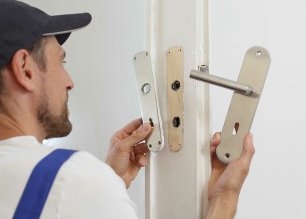 Handwerker tauscht Türklinken